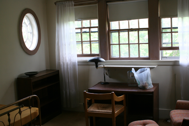 3 windows looking west, with desk, lamp, chair, antique shelf - Large airy studio, walk to to Law School, in Victorian house, private bath, walk-in closet, porch