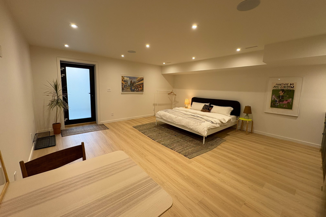 Entry with view of dining area and king size bed - Spacious suite with kitchenette and in-floor heat in a Victorian home at Gladstone /