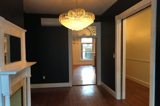 Living room, with chandelier and fireplace - Biddle Mansion Townhome