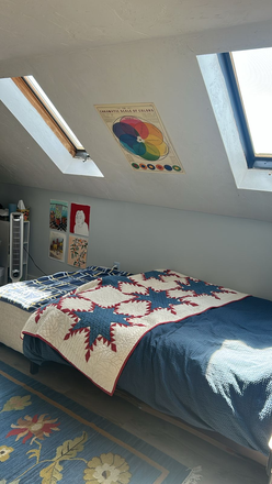 Picture of bed and skylights above it. - Spacious and Full of Light - Attic Room Apartments