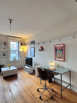 Glass desk in living room with comfy rolling desk chair - Huge Sunny 1 BR Apartment for Rent, Less Than 2 Blocks from Subway, Near all Amenities