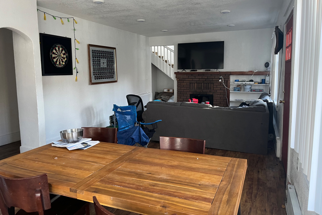 First floor - with dining room table, tv, couch and dart board - 960 14th Street House