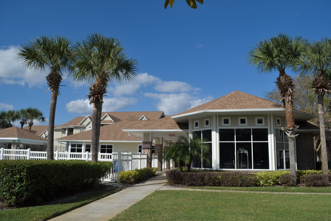 a house with palm trees in front of it - Tivoli Orlando Apartments