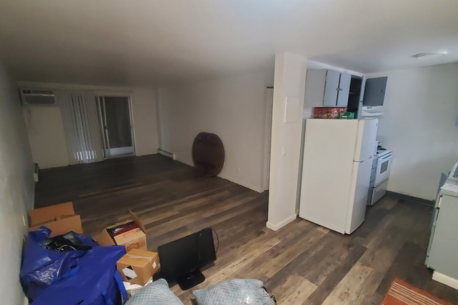 Living room and fridge. Porch door goes out the back. - The Cove Apartments #205