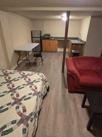 Bed looking at kitchen area - Basement Studio Apartment (Utilities included, pets allowed)