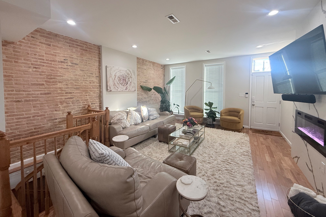 Living room with electric fireplace - Townhome walkable to Johns Hopkins Hospital and Hopkins East Baltimore campus