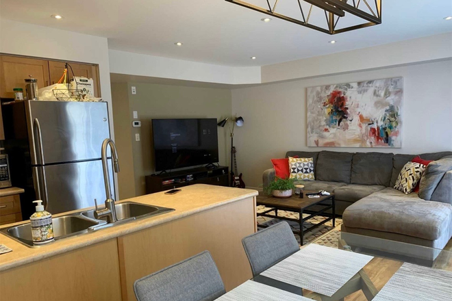 Kitchen and living room - Fully furnished condo with three bedrooms, 2 baths, laundry in the unit, and a full kitchen