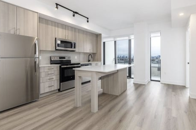 kitchen - New condo unit with 2 + 1 bedrooms, 2 bathrooms, an open concept kitchen, and ensuite laundry