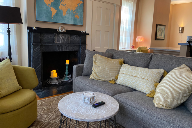 Living room with TV and authentic marble fireplace for looks only - South-facing one bedroom in tranquil setting, historic home