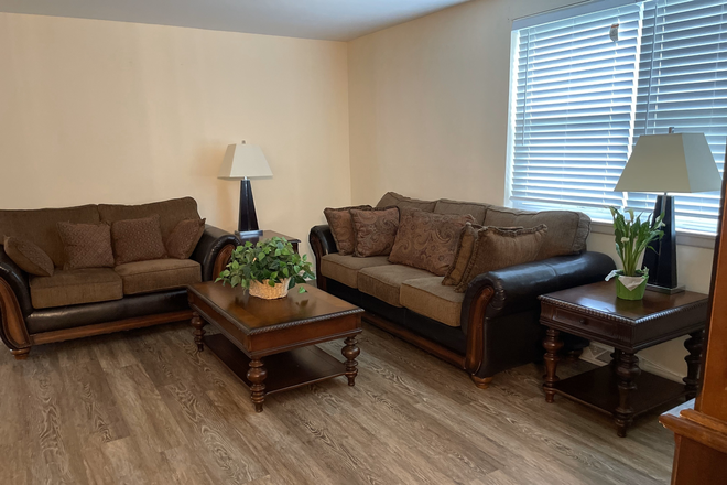 Spacious living room with couch, table, and shared space—great for relaxing or group study. - Affordable Housing – Easy Access to Loyola, John Hopkins Homewood, Morgan
