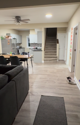 walking into house with couch, tv, dining table, and kitchen to the left and three bedrooms and bath to the right - House close to campus