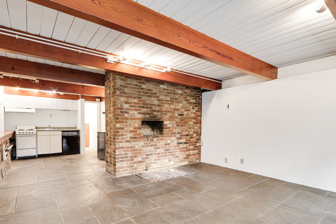 Looking towards interior with exposed brick, stove and small refrigerator - Architect-designed studio apartment on Beacon Hill in 3-unit building