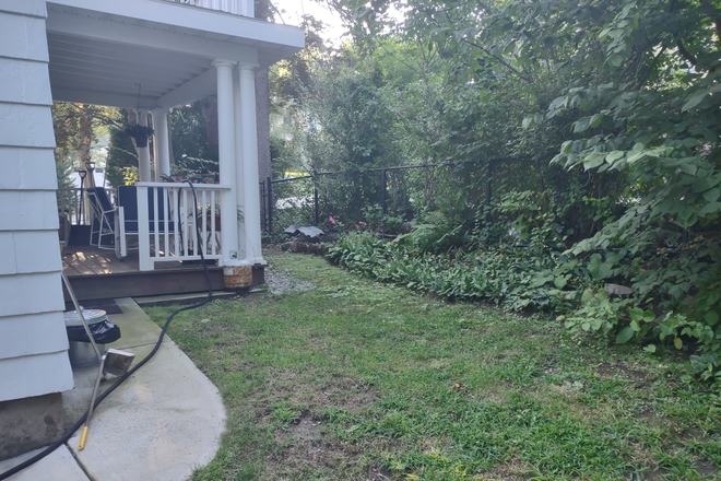 Side yard and porch - Cozy Room in Quiet Neighborhood - Bus Direct to Harvard Sq. (Women only) Apartments