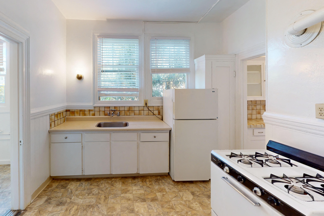 Kitchen with cabinets, refrigerator, stove, and sink - 2129 Haste Street Apartments