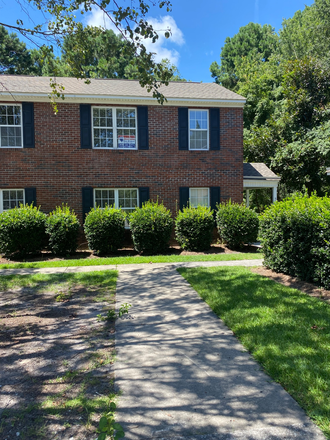 Front view of home - Village Square, 1 mile from campus, parking permit eligible, red brick twin, & pool.