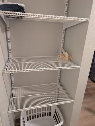 Storage shelves outside bathroom. - Flock 13 Apartments