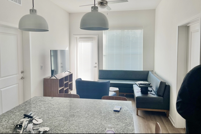 kitchen island and living room of unit - Accolade West $1035/month close to campus-full size in unit laundry 2 heated pools & gym