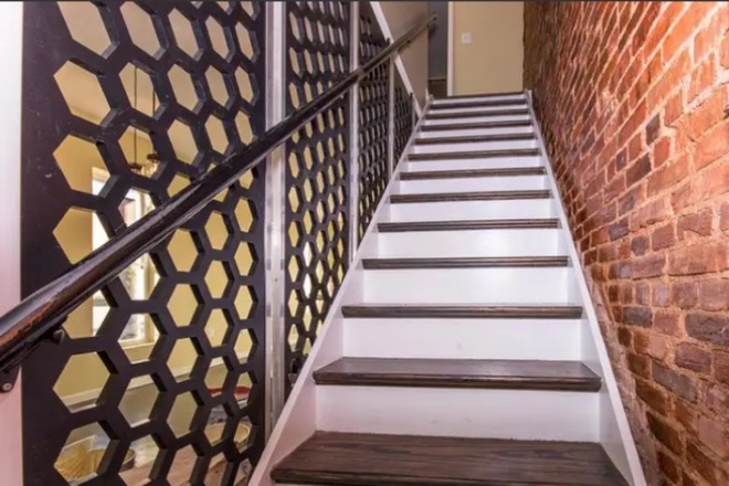 Staircase with brick wall: Cozy stairs with exposed brick and modern railing lead to your private suite. - Charles Village Furnished Master Bedroom with Private En Suite Bath 🏡 House