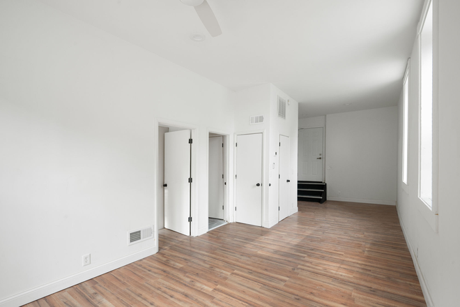 Bright, open living space with natural light and modern flooring. - Mohawk Hill Apts