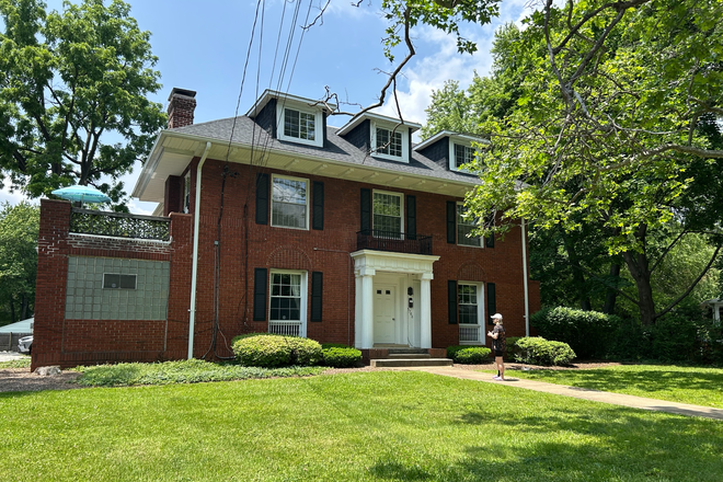 The mansion with private deck on the left and large front lawn - Bright peaceful one bedroom in verdant Mount Washington, walking distant to historic Preakness track Townhome