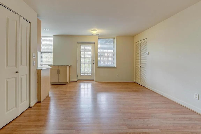 Large Living Room, with hardwood floors, open into private balcony. New windows installed throughout the condo in 2024. - Kingsbury Condo near Wash U campus