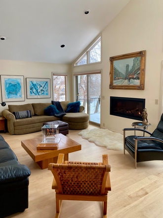 South-facing living room with gas fireplace and two large sofas. - Desnoyer House