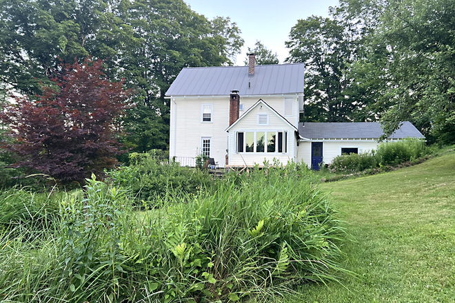 View of house from the north. Irises  bloom in spring, day lilies bloom in summer - Quiet house on 26 acres of rolling fields, woods, & stream. Farm house charm with recent renovations