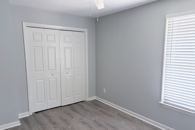 Bright private bedroom angle showcasing the large closet and gorgeous wood-look laminate flooring. - Private BR/Bath for Rent in 2BR Condo - All-Inclusive & Direct Bus to UNC
