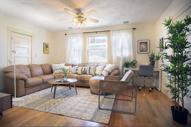 Living room including leather sectional couch. - "The Magnolia Apartment"