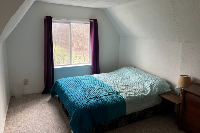 East facing bedroom has queen sized bed, closet, and dresser. - SURROUNDED BY NATURE House
