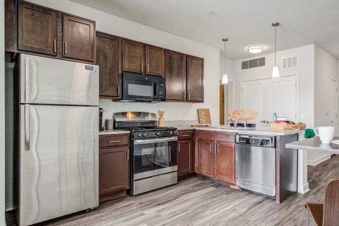 Shared kitchen area. Washer and dryer are in the white double doors. - West Edge Apartments