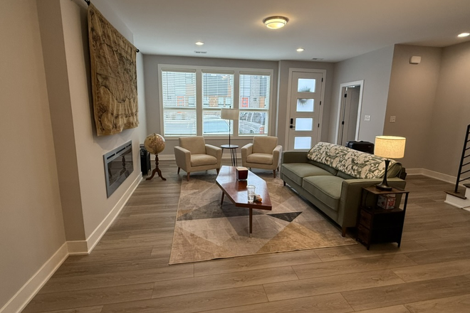 Furnished living room with TV (behind tapestry) - 2 Bedrooms with shared bath available at The Modern Townhome