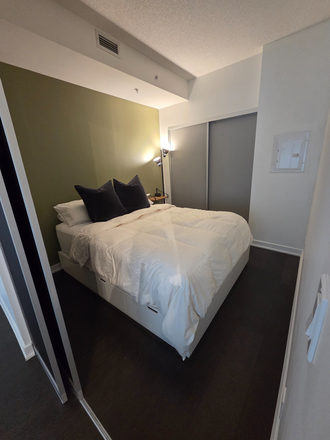 Bedroom with blackout sliding doors, double closet with hanging and drawer storage. Additional storage in under-bed drawers. - Furnished 1 bed/ 1 bath private condo close to Osgoode station