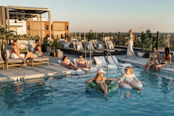 Rooftop pool with lounge chairs, barbeque, and hot tub - Sweetwater Gainesville Apartments