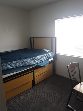 Bedroom with bed and drawers underneath - Campus Village - E. Lansing
