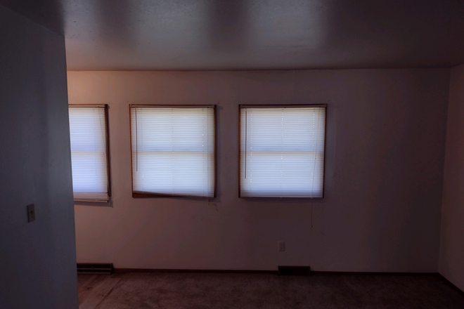 Living room - towards entry and windows - Available August 1, 2026 Apartments