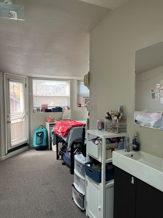 This is the view of the room at its entrance with door to the adjoined balcony at the end. - Spring 2026 Sublease - Apartment Unit on Pleasant Street