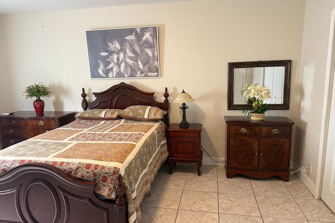 Comfortable furnished sleeping area with bed, nightstand, dresser, mirrors and ample storage. - Furnished Private Studio Near FIU – Private Entrance, Bathroom and Parking House