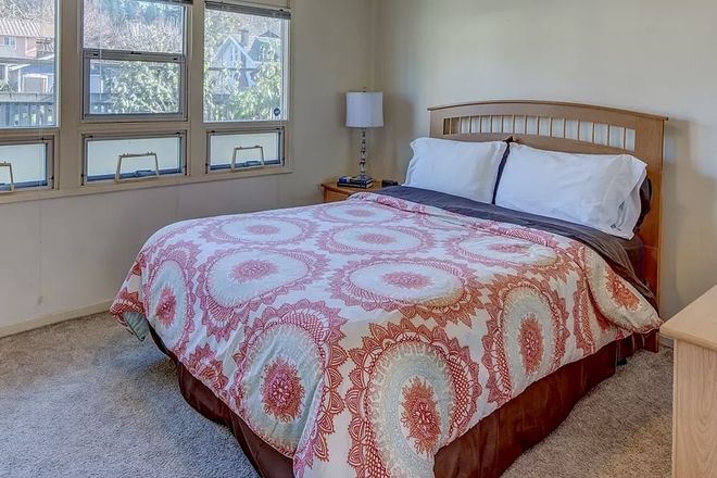 Primary bedroom with windows overlooking the garden - 2- bedroom cottage that is walkable to Knight Law School House