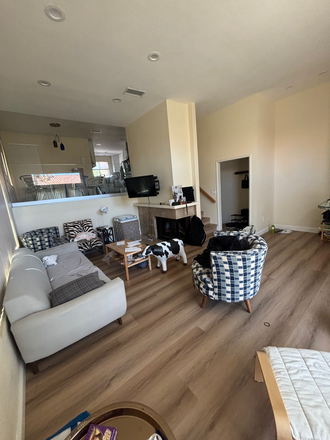 A photo of the living room. It depicts the whole living room, including a fireplace, as well as the dining area's view of the living room. - La Jolla Village Apartment