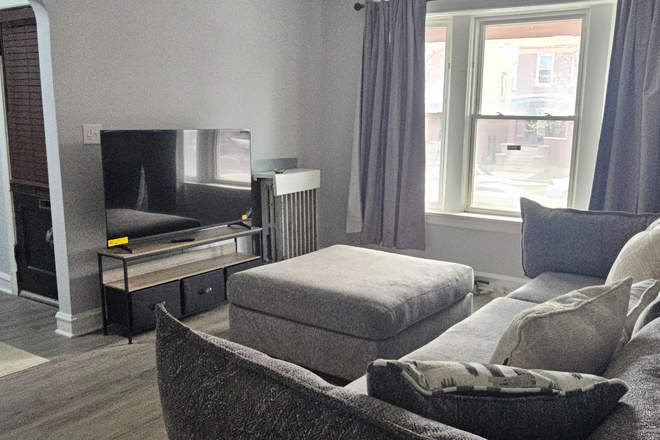 Living room with natural light and comfortable seating - All-Inclusive Furnished 2BR | No Utility Bills | Garage Parking | Convenient to UIC (25–30 Min) Apartments