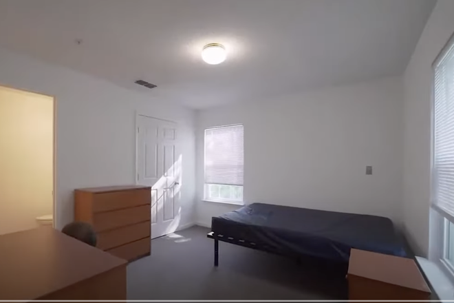 Bedroom with a walk in closet, bed, drawer and bathroom - UMD Courtyards Summer Sublet Apartments