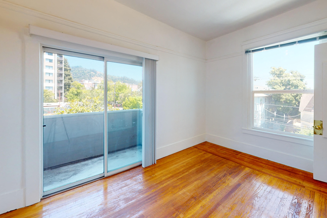 Living room with wood-like floors and sliding glass doors - 2333 Channing Way Apartments