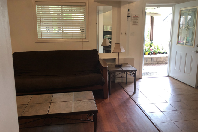 Main entrance to living room and walk out to backyard - Private 1-bedroom legal basement apartment , separate entrance, and steps to bus stop