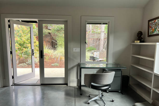 Living area with french doors and large window. - 2738 Elmwood Avenue Cottage ADU Rental