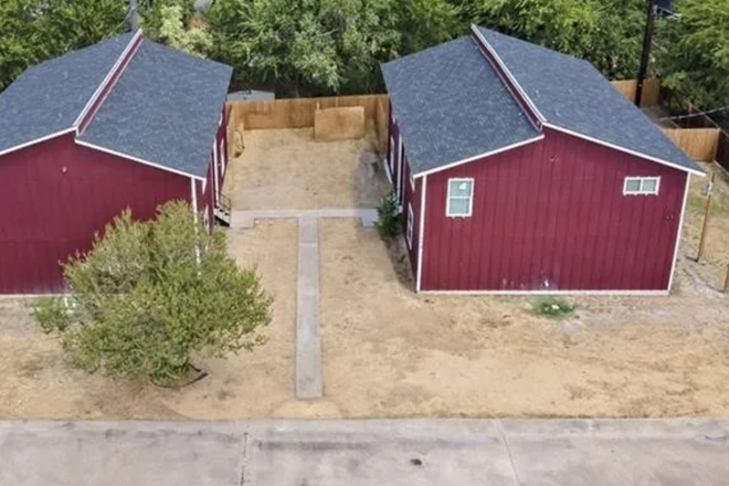 outside of the fourplex with parking lot in front of it. - Apartment close to campus