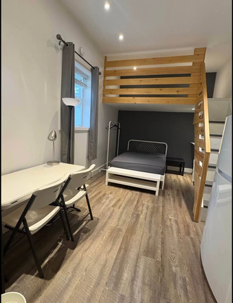 Bright main living and sleeping area with large window, loft above and flexible dining or study space. - Studio Suite with 1 Bathroom & Kitchen