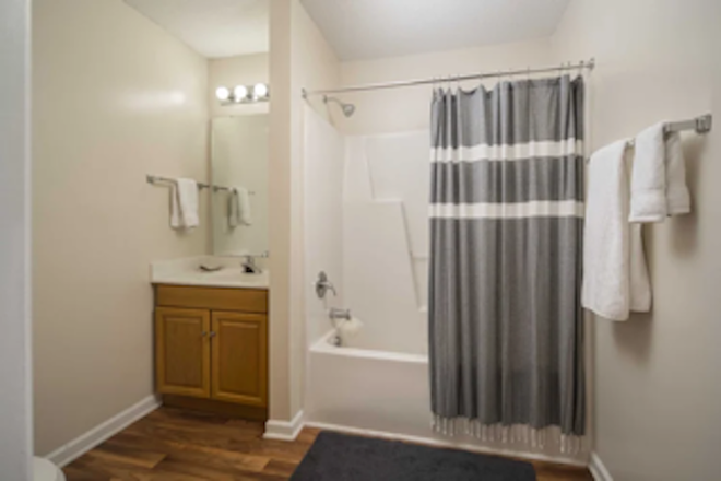 Each bedroom has its own bathroom which includes a shower, toilet, sink, mirror, cabinet, and storage shelves. - Mountaineer Village Apartments