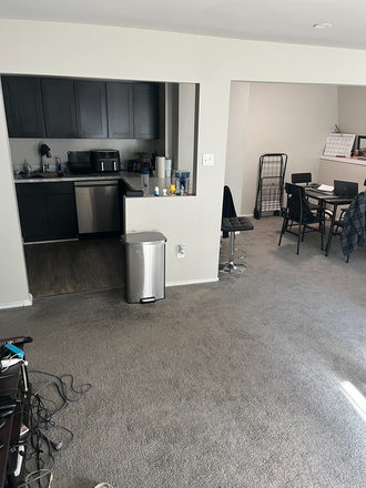 the kitchen is behind that silver trash can. TVs and game systems are somewhat in the picture. - The Hills at KenilWorth Apartments