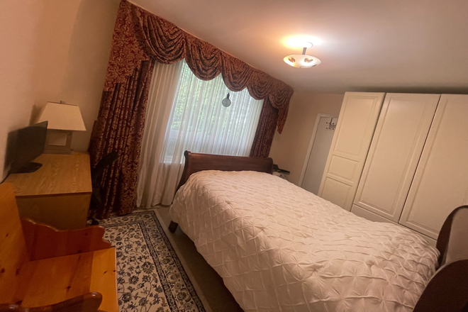Master bedroom  on the first floor with a double bed, study desk, and chair. - Quiet Toronto Home – Private Upstairs & Basement Rooms